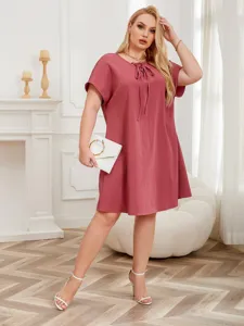 Plus size casual short sleeve dress detail shot showing tie neck design and loose fit.