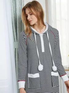 Vue détaillée de la chemise de nuit longue à capuche rayée noir et blanc avec pompons.