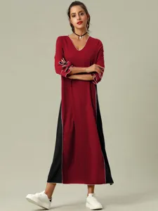 Elegante vestido largo de manga larga con inserciones negras y detalles blancos.