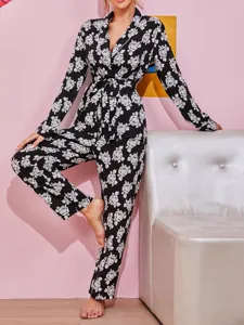 Women's black and white floral print long sleeve pajama set with belt and matching pants.