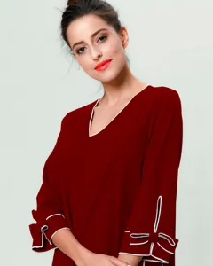 Vista detallada del vestido largo rojo oscuro de manga larga con cuello en V y ribetes blancos.