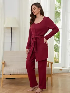 Détail de l'ensemble de loungewear en maille gaufrée rouge avec robe nouée et pantalon.