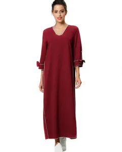 Detalles del vestido largo rojo de manga larga con ribetes blancos y lazos en las mangas.