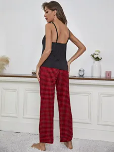 Detailed view of the women's black camisole and red plaid pajama pants loungewear set.
