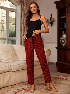 Close-up detail of women sleeveless black camisole and red plaid pajama pants set.