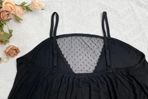 Détail de chemise de nuit camisole en modal noir, bretelles fines et empiècement dentelle.