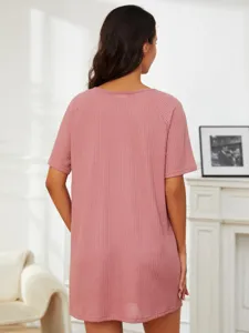 Détail de dos de la robe de détente rose en tricot gaufré à manches courtes dans la pièce.