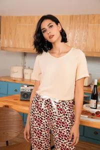 Women's two-piece pajama set featuring a short-sleeve V-neck top and chic leopard print pants.