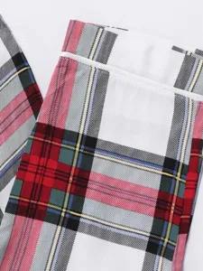 Kids plaid pajama pants fabric detail close-up, soft and cozy tartan textile texture.