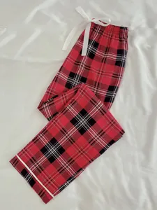 Detail view of red black plaid women lounge trousers soft pajama pants with white ribbon drawstring.
