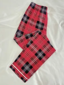 Close-up view of red black plaid pajama pants showing fabric pattern and elastic waistband.