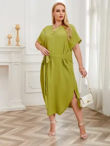 Detailed view of women plus size green pleated dress featuring comfortable loose fit and belt.