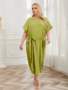 Detailed view of the olive green pleated midi dress with short sleeves and matching waist belt.