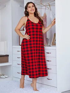 Detail shot of the plus size red and black plaid camisole nightgown worn in a bright bedroom.