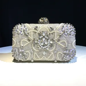 Close-up detail of luxury silver beaded evening clutch with shimmering crystals and pearls.