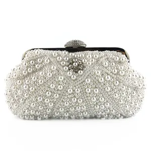 Handmade pearl clutch evening bag with metal frame and rhinestone clasp for wedding party.