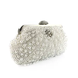 Close up view of exquisite handmade white pearl evening clutch bag with sparkling crystal clasp.