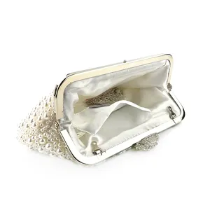 White handmade pearl evening clutch bag with metal kiss-lock frame and crystal clasp.