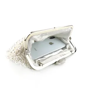 Handmade pearl evening clutch bag detail showing interior capacity with metal frame and clasp.