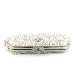 Handmade pearl evening clutch bag detail showing delicate beadwork and rhinestone clasp close-up.