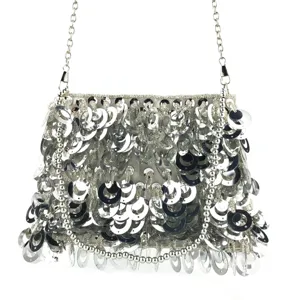 Détail de sac de soirée à paillettes argentées, anneaux brillants et chaîne chic.