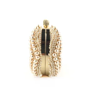 Detailed side view of luxury handmade pearl evening clutch bag with elegant gold metal frame.
