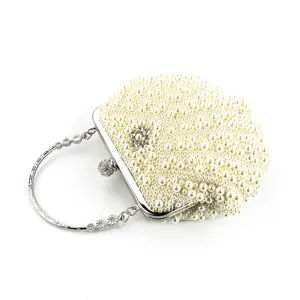 Detailansicht einer eleganten perlenbesetzten Muschel-Abendtasche mit Metallringgriff.