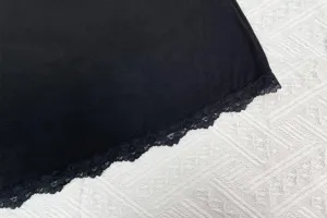 Détail de l'ourlet de chemise de nuit noire en modal avec élégante bordure en dentelle fine