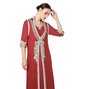 Detailed view of the elegant brick red long dress with exquisite white and green embroidery.