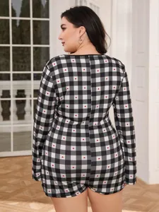 Plus size black and white plaid long sleeve romper detail view featuring cute red heart print.