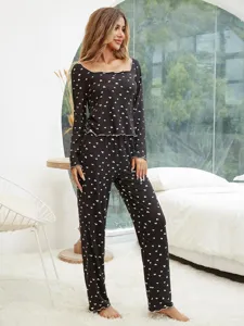 Detail view of a cozy black long-sleeve pajama set featuring cute white heart patterns.