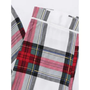 Children red plaid pajama pants detail view showcasing classic holiday tartan pattern fabric.