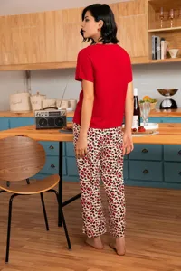 Detail view of women's short-sleeve lounge set with stylish leopard trousers in summer kitchen scene.