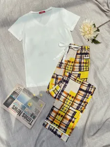 Detailed view of women's short-sleeve pajama set with yellow plaid pants in a cozy scene.
