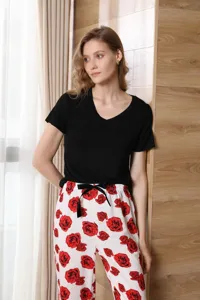 Detail view of women's short-sleeve pajama set with rose print pants and black V-neck top.