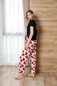 Women short sleeve pajama set featuring black top and red rose print pants for comfy sleepwear.