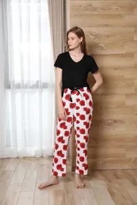 Detailed view of the women's short sleeve top and red rose pajama pants set in a cozy indoor setting.