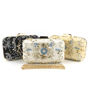 Vista dettagliata della pochette da sera con perline fatte a mano, strass e catena in metallo.