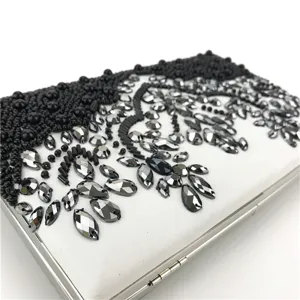 Detailed view of handmade beaded evening clutch with sparkling crystals and silver metal frame.