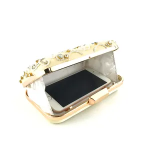 Elegante pochette da sera color champagne con strass brillanti e perle, telaio metallico.