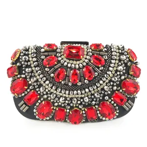 Vue détaillée du sac de soirée de luxe fait main avec cristaux rouges et strass argentés.