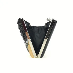 Close-up detail view of the handmade beaded evening clutch, showing delicate black beads and metal frame.
