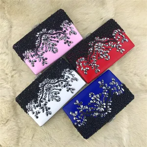 Detailed view of evening clutch with handmade black bead embroidery and sparkling crystal stones.