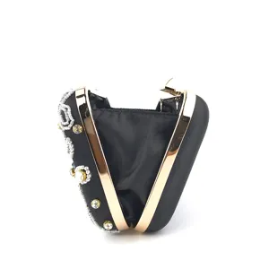 Vista dettagliata della borsa da sera in satin nero con montatura dorata, ricamo di perline e strass.