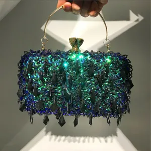 Handgemaakte pailletten avondclutch tas met metalen ringhandvat en kraaldetails.