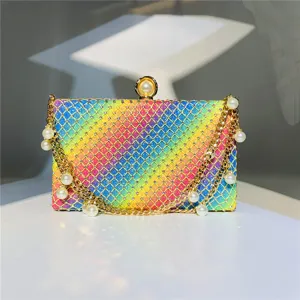 Detailed view of the colorful rhinestone evening clutch bag with elegant gold chains and pearls.