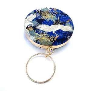 Blue crane print round evening clutch detail with gold frame and sparkling rhinestone ring handle.
