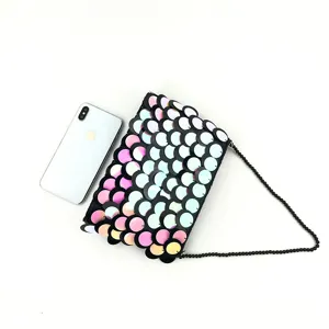 Detailed view of the gradient sequin clutch bag featuring delicate beaded chain and scale design.