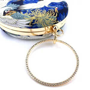 Exquisite rhinestone ring handle and crane print detail on the elegant round evening bag.