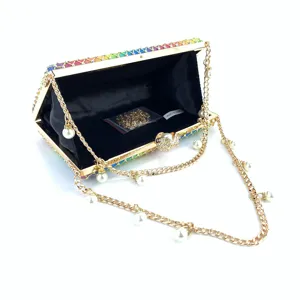 Rhinestone evening clutch bag interior detail, showing pearl chain, gold frame, and black lining.